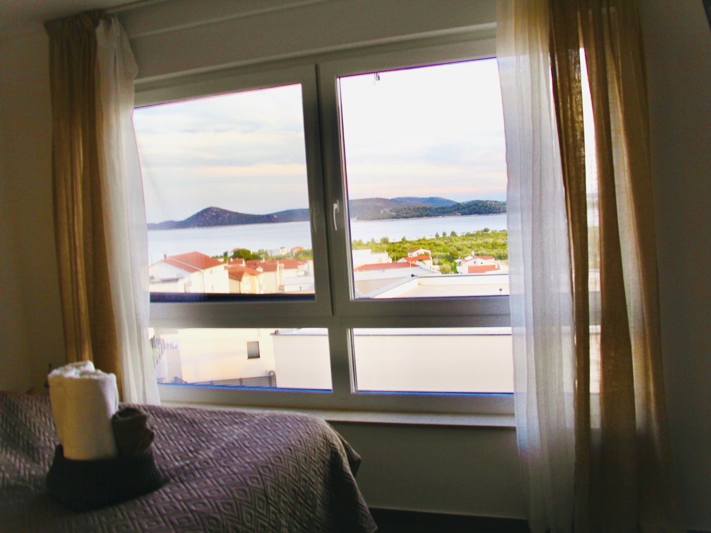 A bedroom with the sea visible through the window