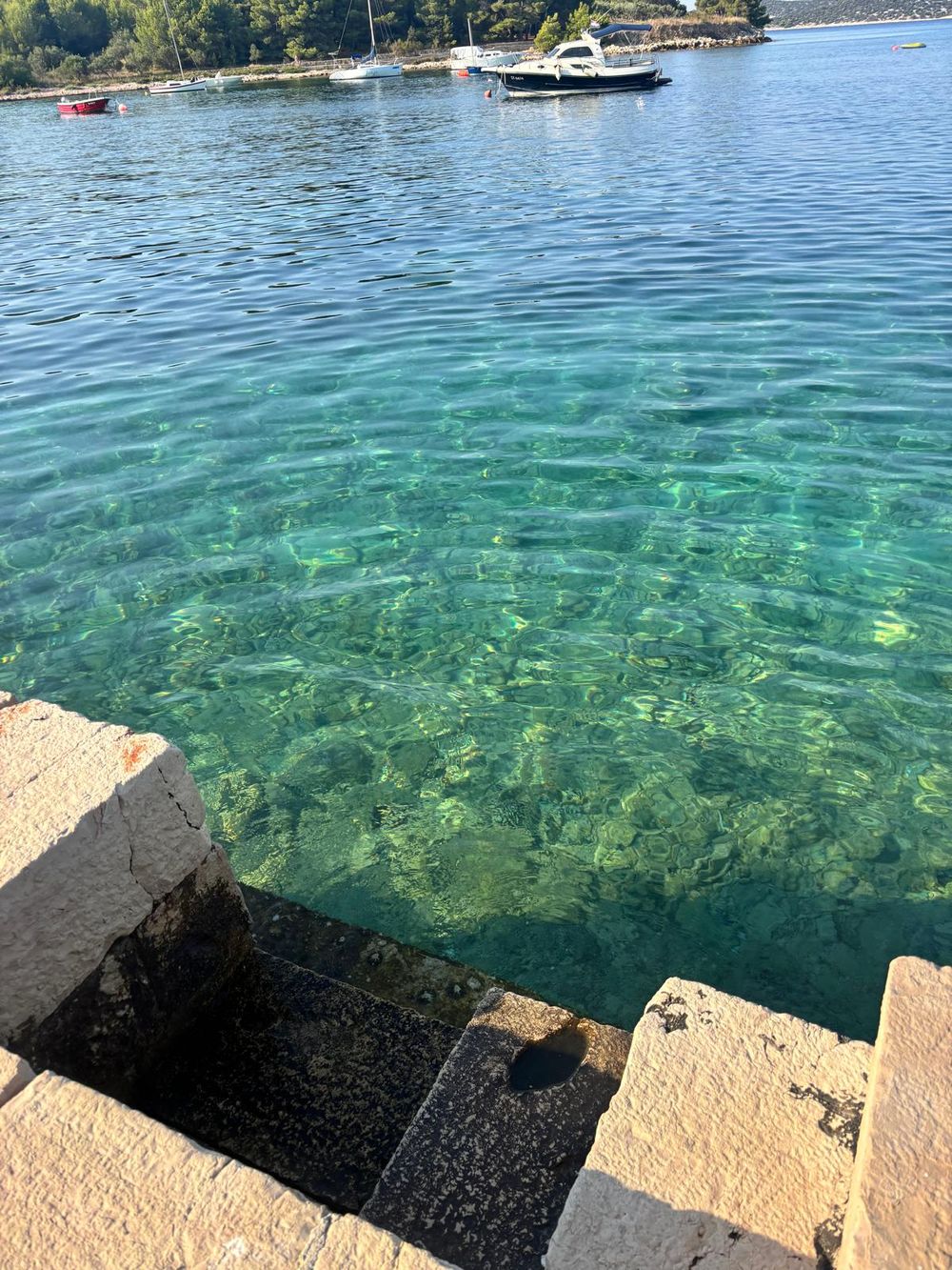 Clear turquoise water beside a stone jetty