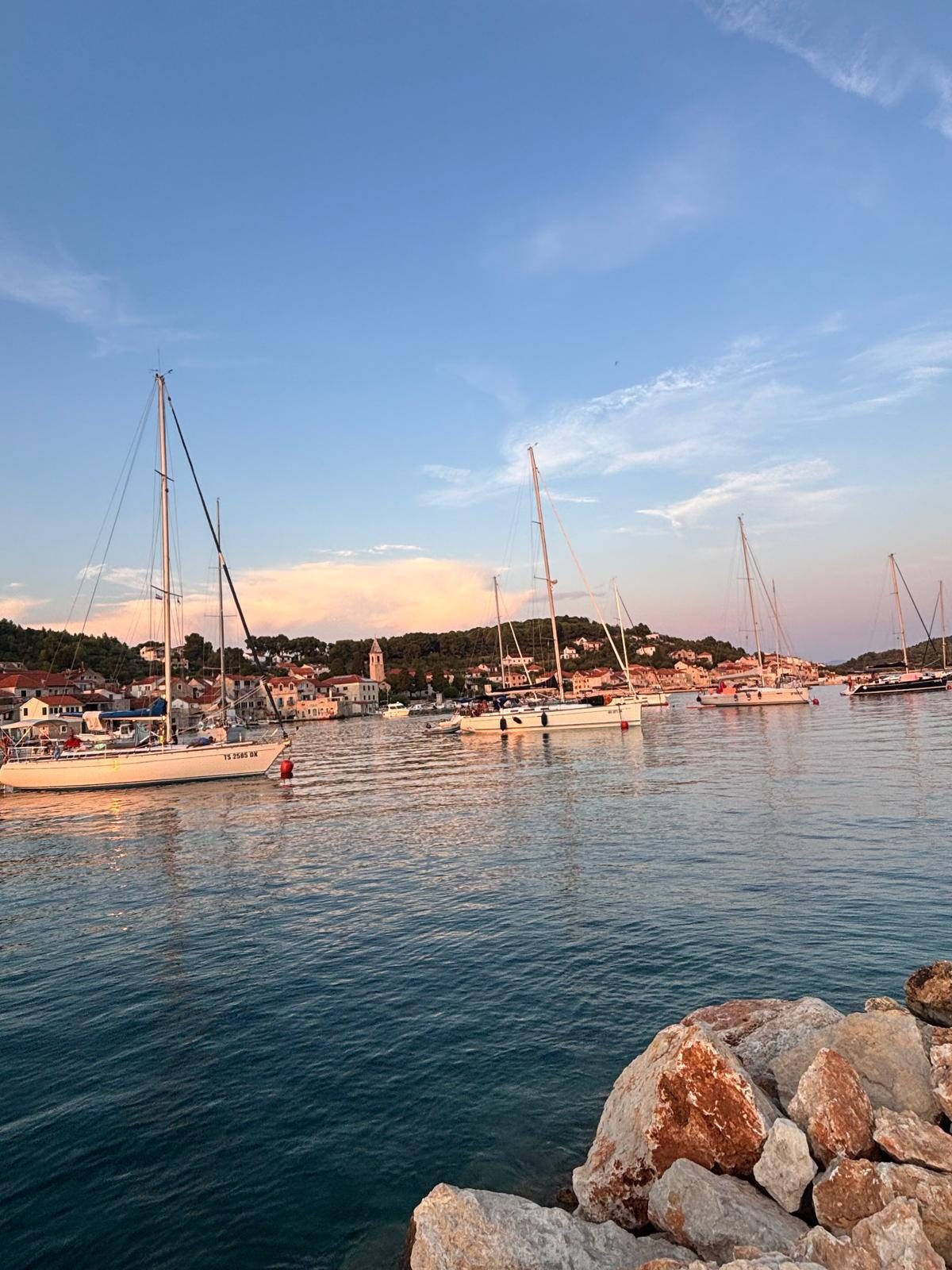 Sailing boats in the harbour in the evening light, the town behind