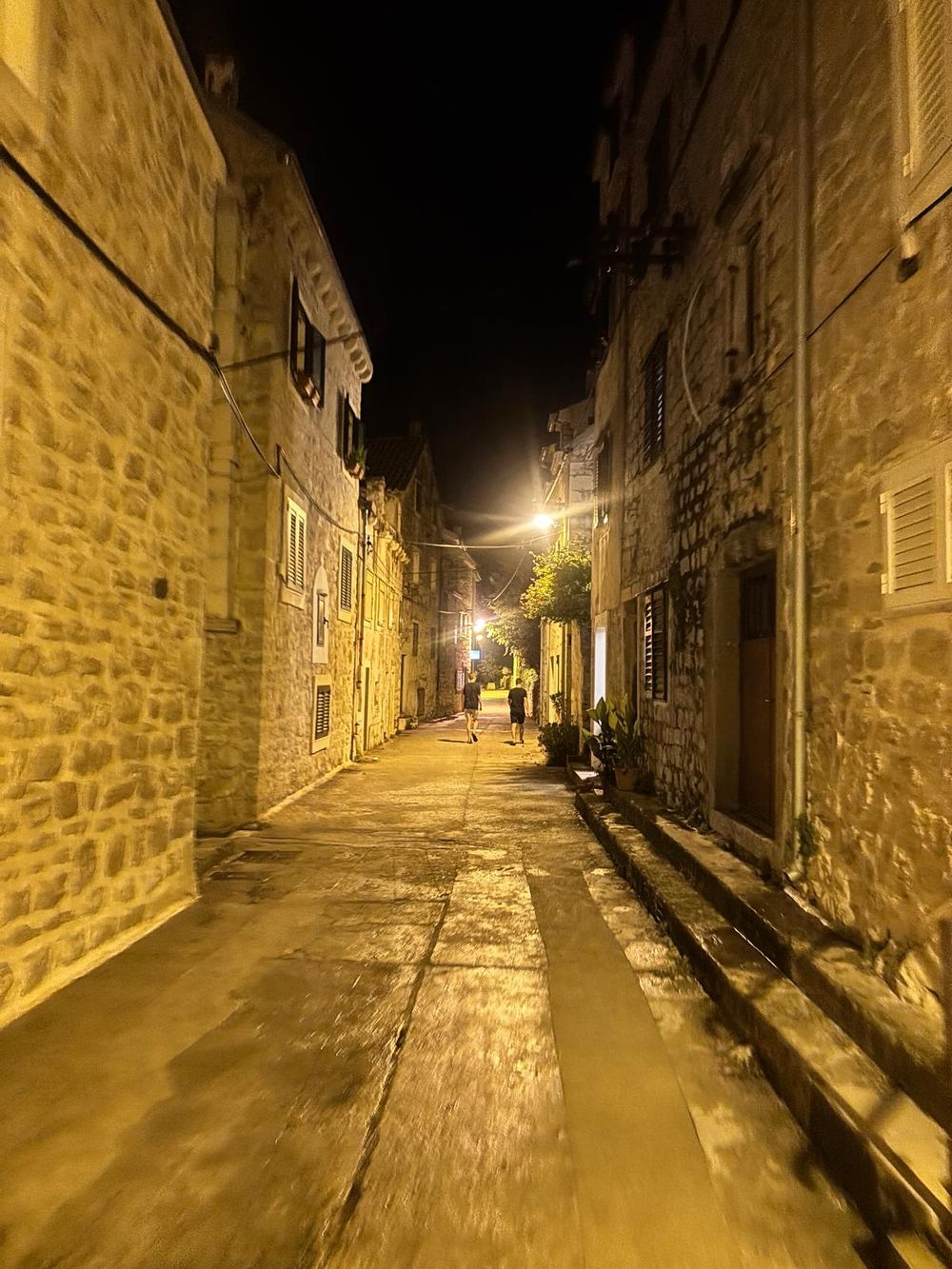 A narrow lane between old stone houses in the evening